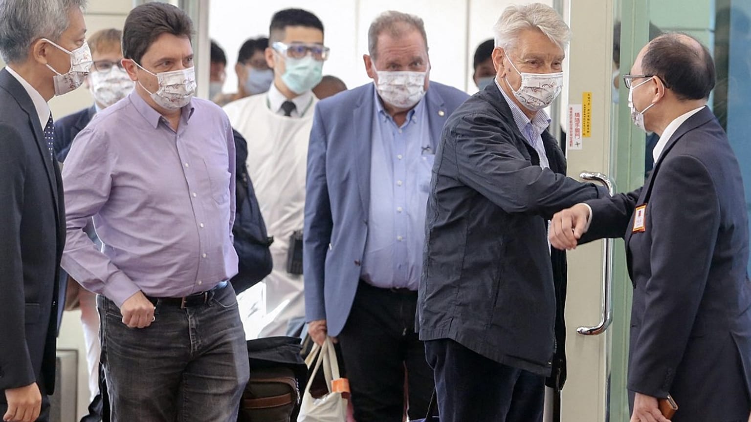 Taiwan's deputy foreign minister Harry Tseng (R) greets French Senator Alain Richard (2nd R) leading a delegation arriving at the Taoyuan international airport on October 6.