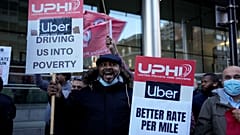 People take part in an Uber drivers' protest outside the company's offices in east London, Wednesday, Oct. 6, 2021.