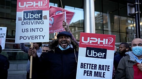 People take part in an Uber drivers' protest outside the company's offices in east London, Wednesday, Oct. 6, 2021.
