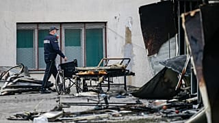 A police officer walks past burned hospital equipment on the site of the fire.