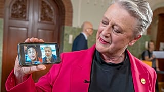 Берит Рейсс-Андерсен держит смартфон, на экране которого фотографии лауреатов Нобелевской премии мира этого года