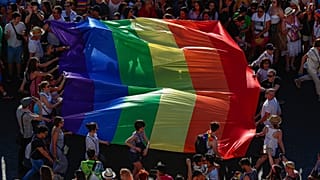 Participants of the annual LGBT+ pride parade carry the rainbow flag in Madrid.