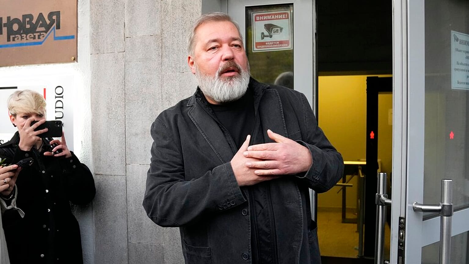 Novaya Gazeta editor Nobel Peace Prize Dmitry Muratov greets reporters at the Novaya Gazeta newspaper, in Moscow