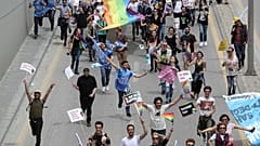 Protesters hold signs and a rainbow flag during a demonstration in Ankara in May 2019.