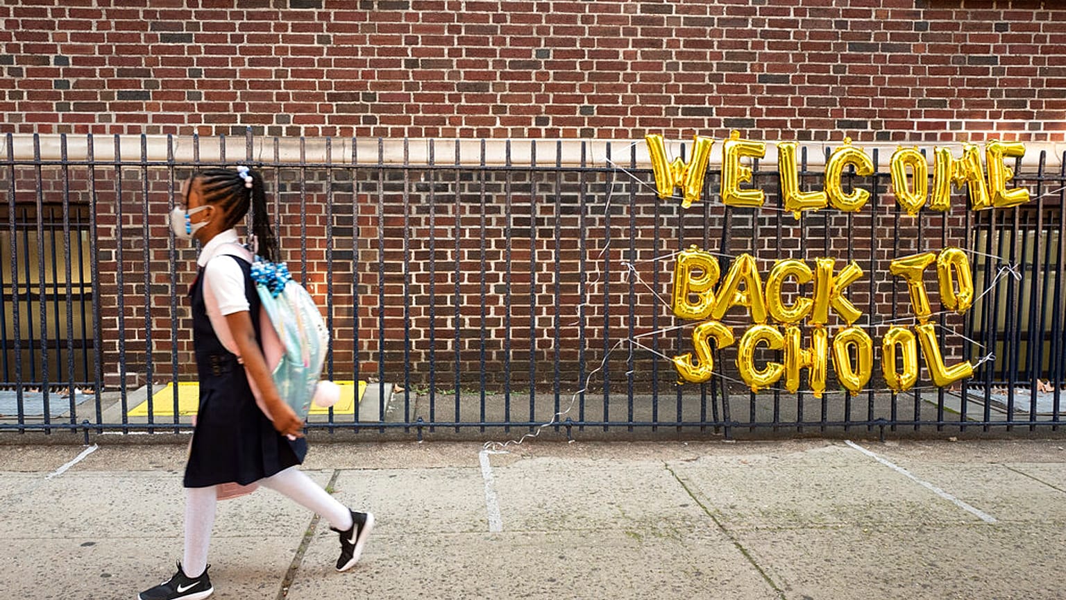 Mädchen mit Maske auf dem Weg in die Schule in New York