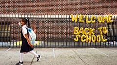 Mädchen mit Maske auf dem Weg in die Schule in New York
