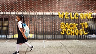Mädchen mit Maske auf dem Weg in die Schule in New York