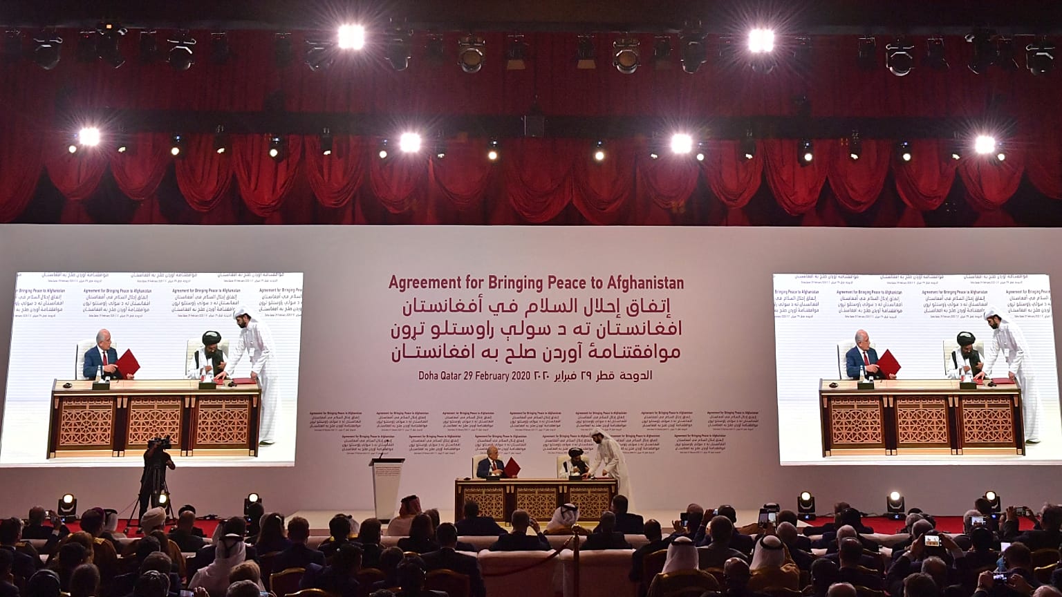 الممثل الأمريكي الخاص للمصالحة في أفغانستان، زلماي خليل زاد والشريك المؤسس لحركة طالبان الملا عبد الغني بردار يوقعان اتفاقية سلام في العاصمة القطرية الدوحة. أرشيف