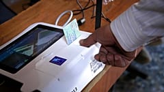 Un uomo fornisce la sua impronta digitale prima del voto, in un seggio elettorale a Baghdad, Iraq