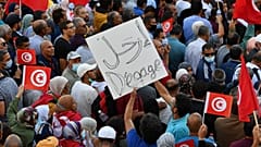 تونسيون يرفعون الأعلام الوطنية خلال مسيرة ضد رئيسهم على طول شارع الحبيب بورقيبة في العاصمة تونس في 10 أكتوبر 2021.