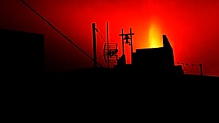 Silueta de una vivienda con la erupción del volcán Cumbre Vieja como telón de fondo en la isla española de La Palma