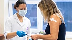 Juhász Tünde tüdőgyógyász szakorvos átadja az oltási igazolást egy nőnek, miután beoltotta a német-amerikai fejlesztésű Pfizer-BioNTech koronavírus elleni oltóanyaggal