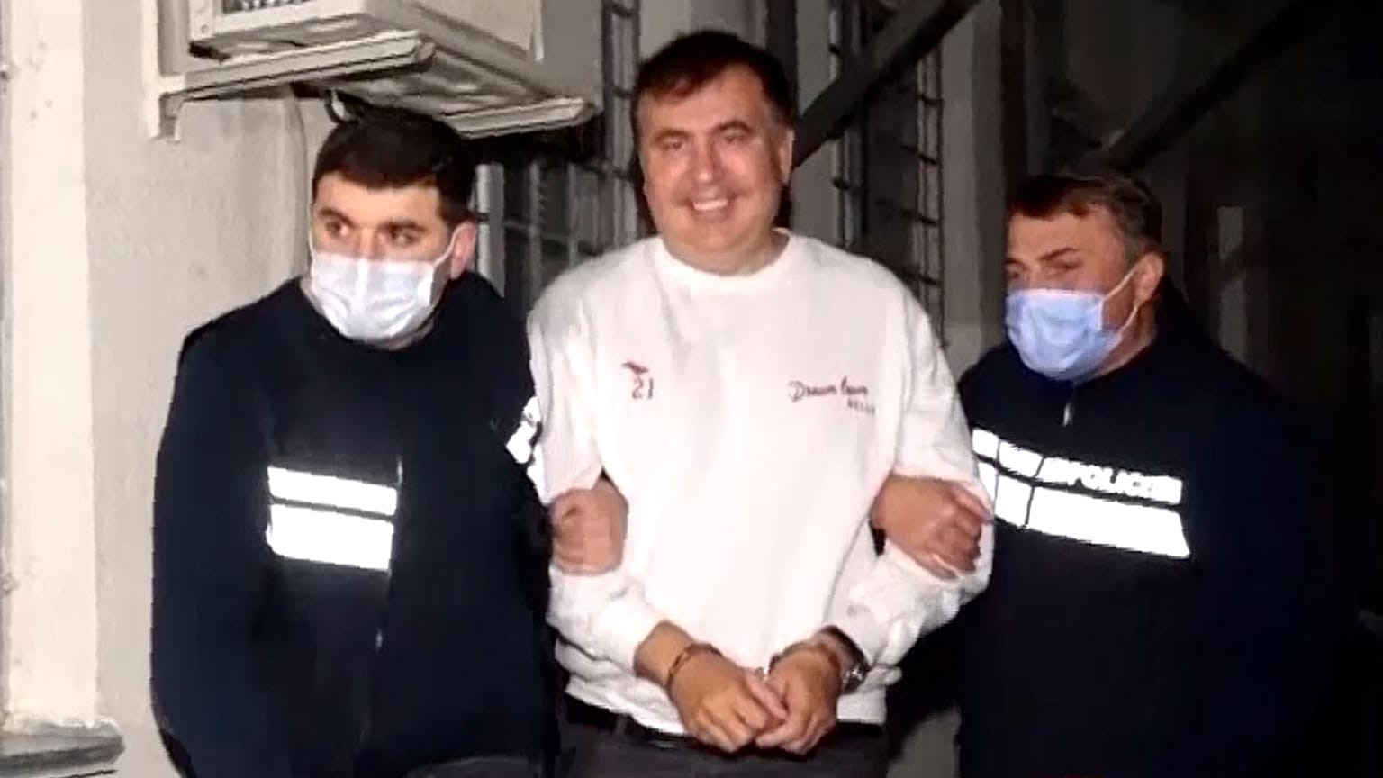 Georgian Police officers escort former President Mikheil Saakashvili after he was arrested in Rustavi.