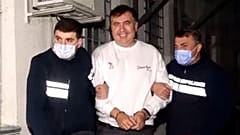 Georgian Police officers escort former President Mikheil Saakashvili after he was arrested in Rustavi.