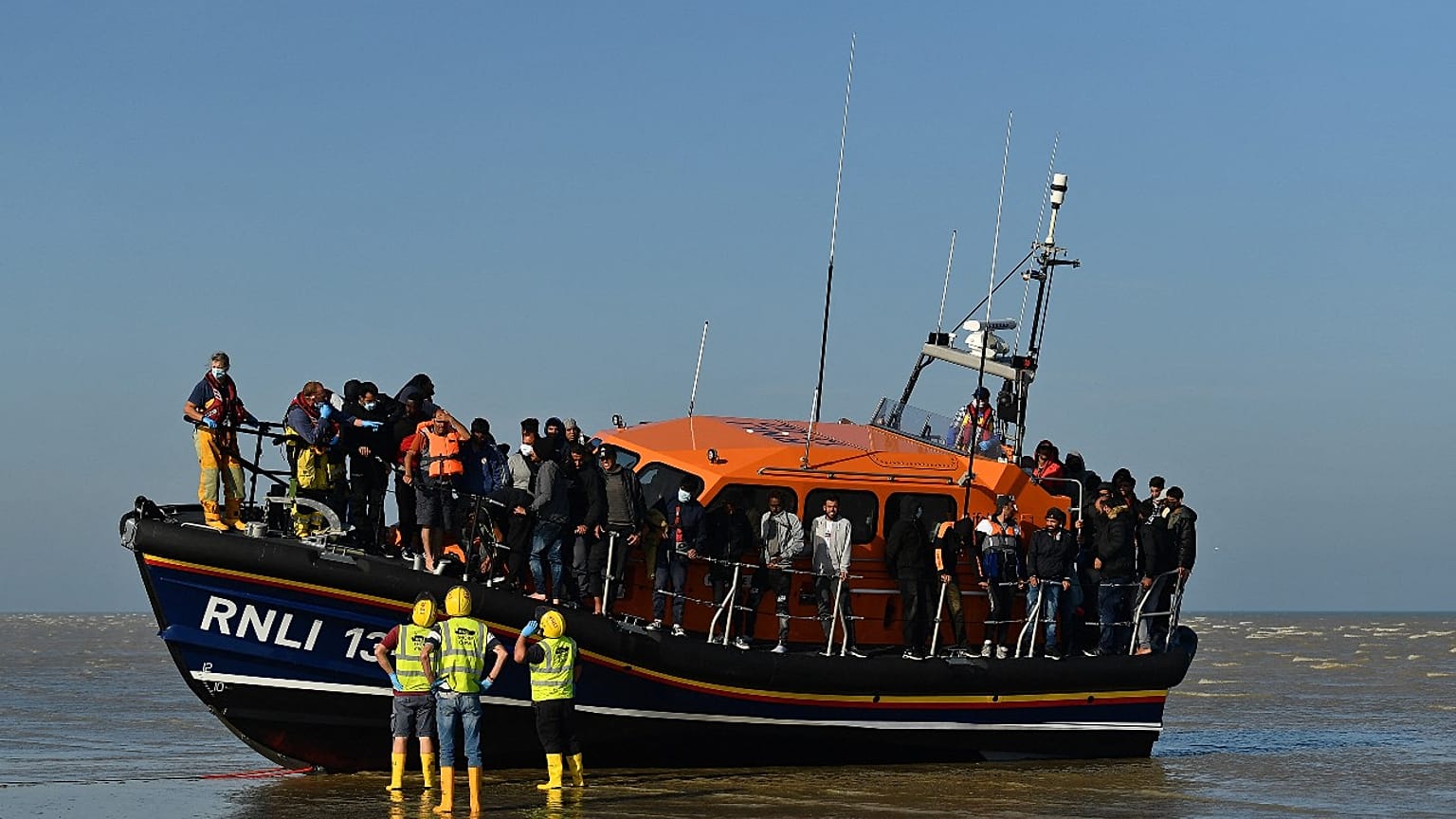 Migrants stand aboard an RNLI (Royal National Lifeboat Institution) lifeboat after being rescued crossing the English channel at Dungeness, England, September 7, 2021.
