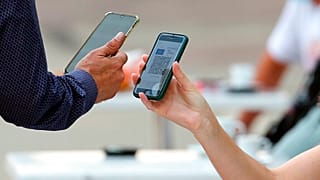 Un client présentant son pass sanitaire à un serveur dans le sud de la France (11 août 2021)