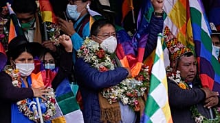 El presidente de Bolivia, Luis Arce, en el centro, canta el himno nacional boliviano durante un mitin con sus partidarios en La Paz, Bolivia, el 12 de octubre de 2021.