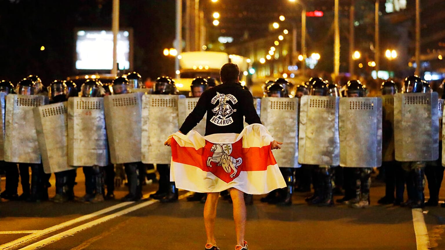  Tarihi Belarus bayrağı tutan bir protestocu polisin önünde duruyor. 9 Ağustos 2020