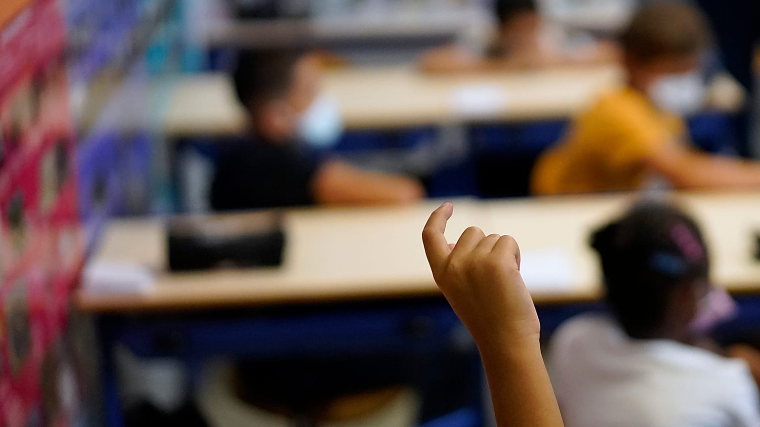 A child raises his finger to speak at the Bouge primary school in Malpasse district of Marseille, southern France, Sept. 2, 2021.