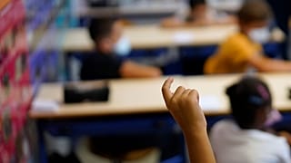 A child raises his finger to speak at the Bouge primary school in Malpasse district of Marseille, southern France, Sept. 2, 2021.