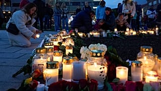 Flowers and candles were left after a man killed several people, in Kongsberg, Norway, Thursday, Oct. 14, 2021