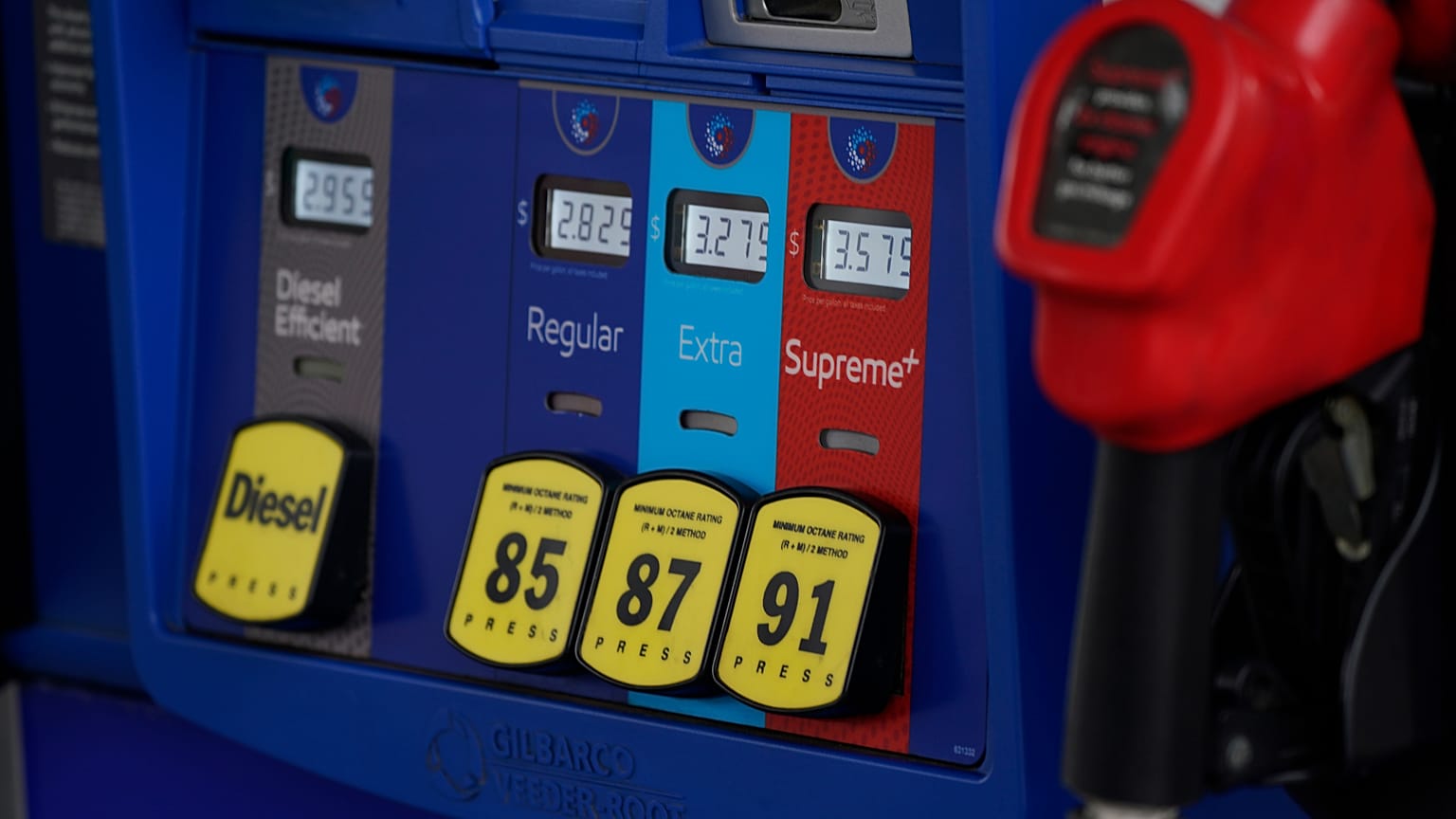 In this May 9, 2021, file photo prices are illuminated above the levers for the different grades of gasoline available at a pump at an Exxon station.