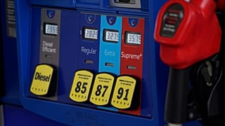 In this May 9, 2021, file photo prices are illuminated above the levers for the different grades of gasoline available at a pump at an Exxon station.
