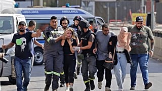 يساعد مسعفون لبنانيون في إجلاء المدنيين خلال الاشتباكات في منطقة الطيونة بالضاحية الجنوبية للعاصمة بيروت، 14 أكتوبر/تشرين الأول 2021