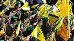 Hezbollah fighters raise their group flags in the southern village of Adloun, Lebanon in May