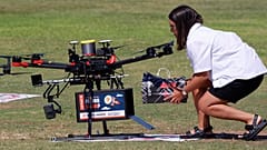 This picture taken on October 11, 2021 in the Israeli coastal city of Herzliya shows a woman loading goods into a drone as it carries deliveries during Drone Intitiative test.