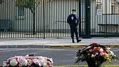 Floral tributes are left in front of the school where teacher Samuel Paty worked, in Conflans Sainte Honorine, Friday, Oct. 15, 2021.