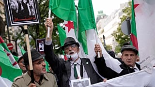 Demonstrators holding Algerian flags chant slogans in Paris, Sunday, Oct. 17, 2021.