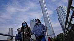 Peatones con mascarillas en el distrito comercial de Pekín, China