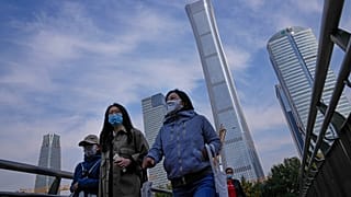 Peatones con mascarillas en el distrito comercial de Pekín, China