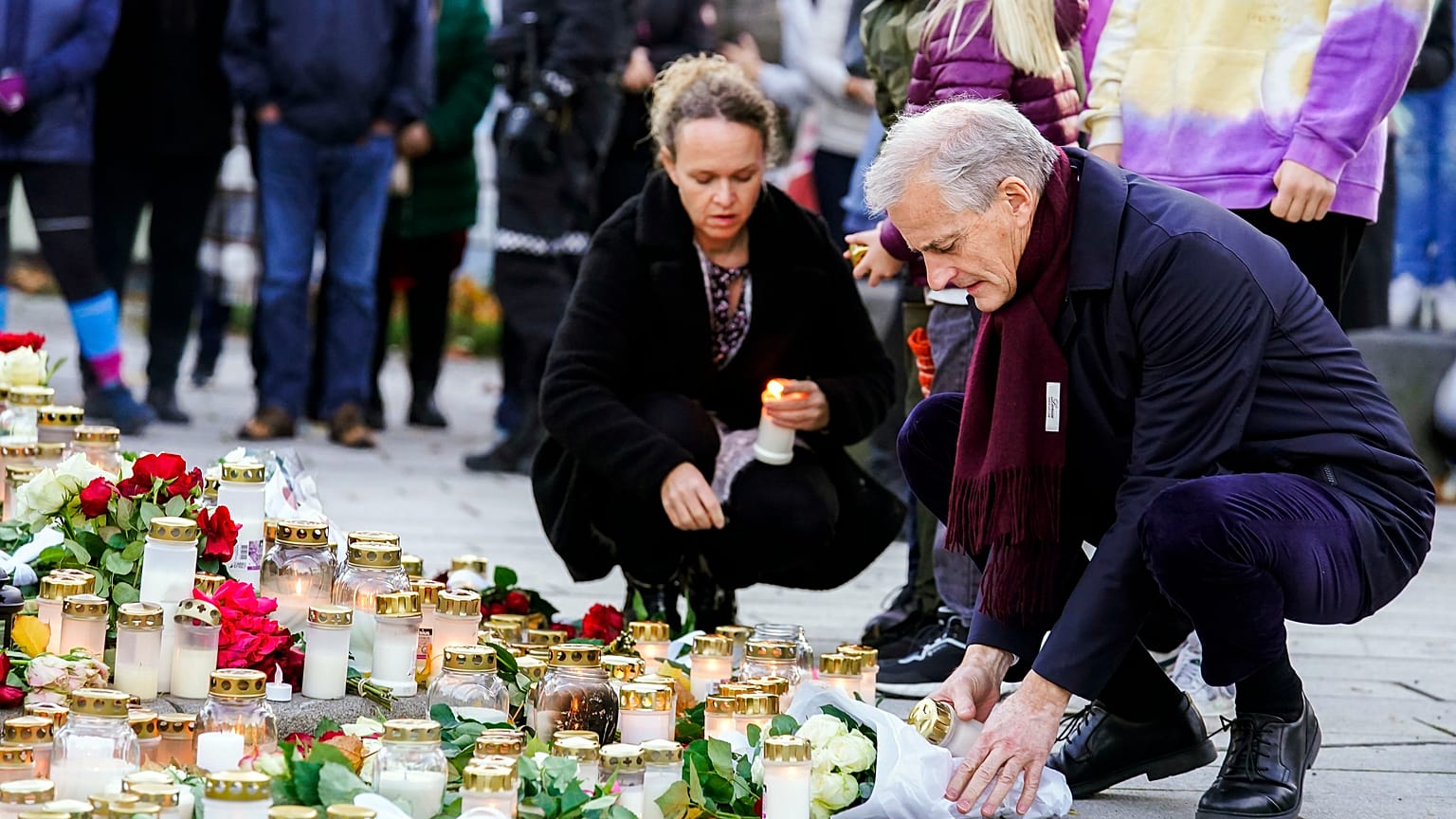 Norway's Prime Minister Jonas Gahr Støre lays flowers and lights candles during his visit to Kongsberg, Norway, Friday, Oct. 15, 2021
