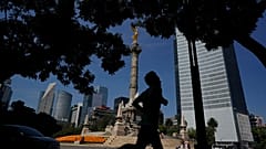 Un hombre trota frente al monumento del Ángel de la Independencia, 18/10/2021, Ciudad de México, México