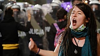 FILE: Under police guard, a crowd protests a decision on abortion by the Constitutional Court, in Warsaw, Poland, on Friday, Oct. 23, 2020.