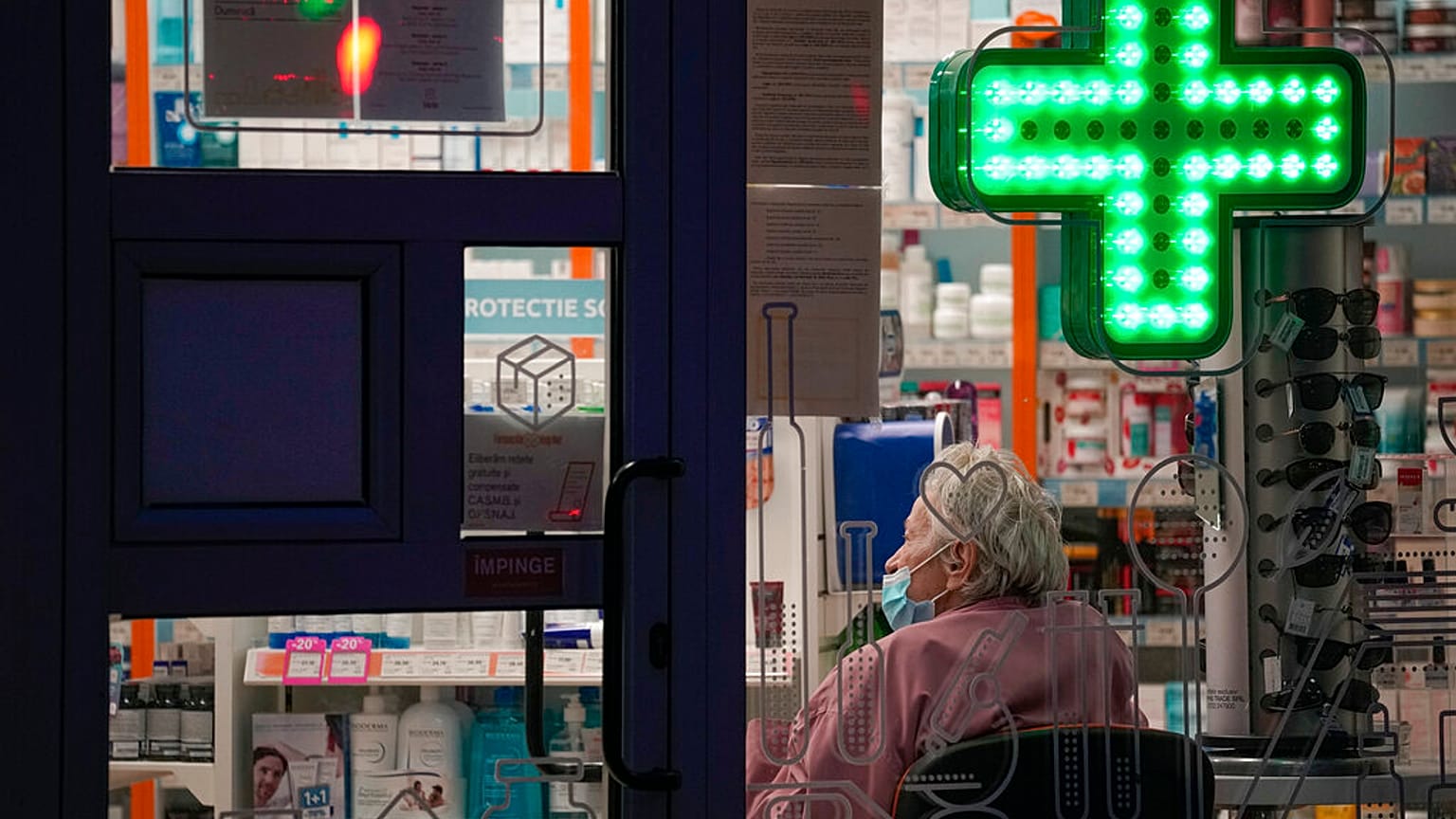 Una anciana aguarda a ser atendida sentada en una farmacia de Bucarest