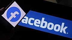 Facebook logo on a smartphone in front of a computer screen