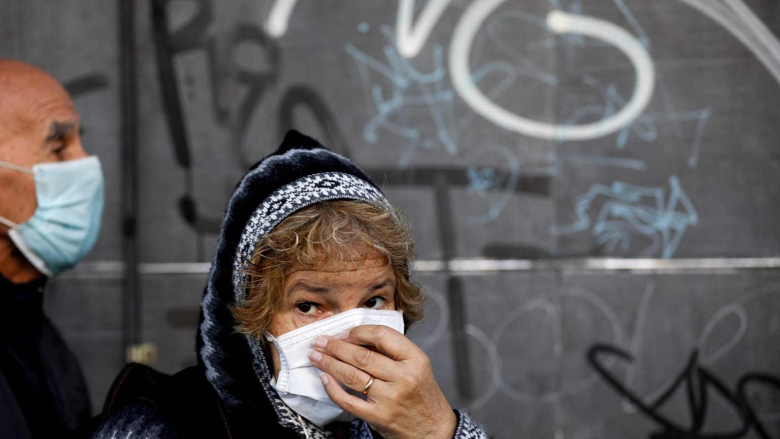 A woman, wearing a protective face mask, waits in line outside a bank, 4/4/2020, Buenos Aires, Argentina
