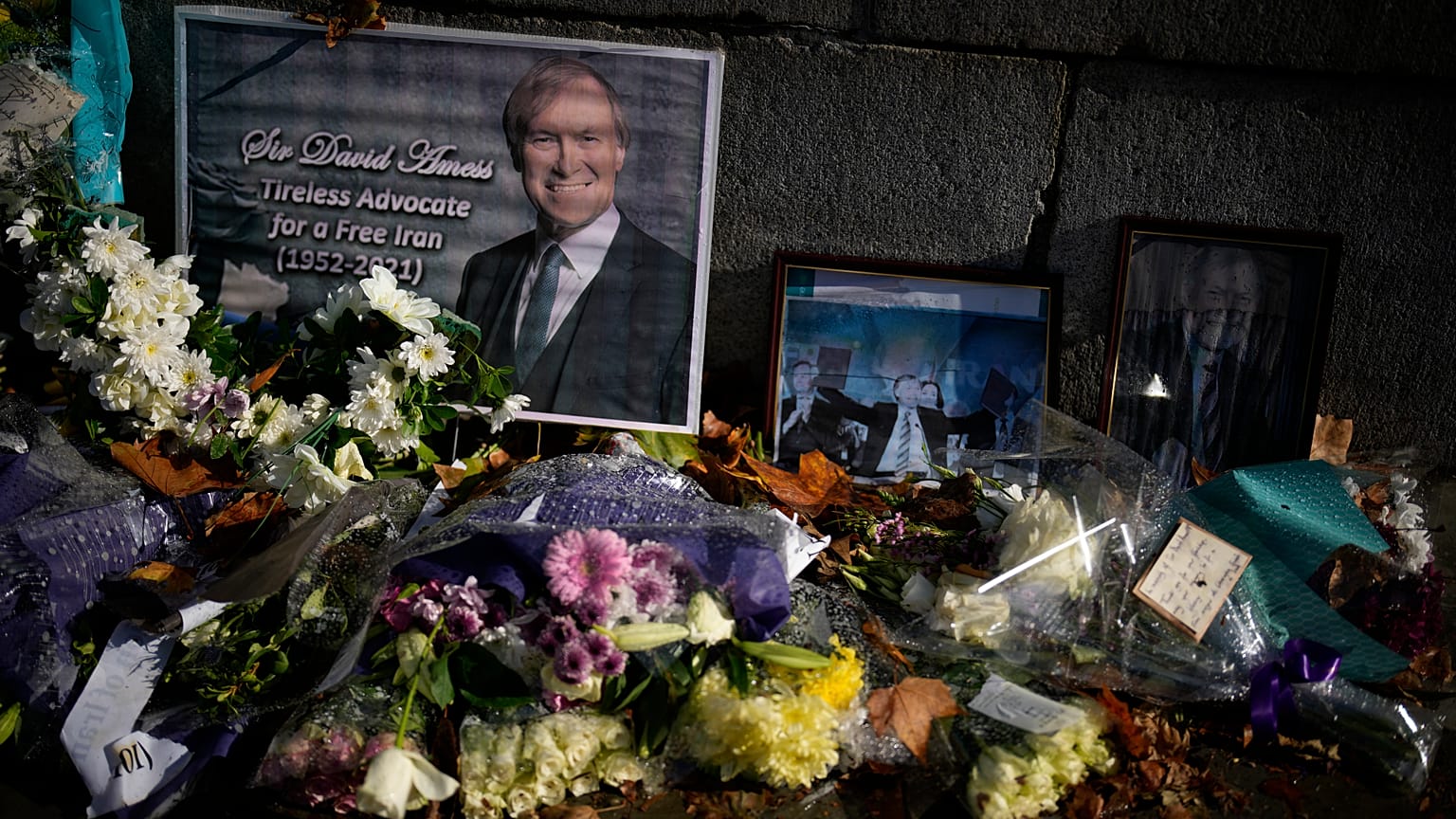 Floral tributes and pictures of British Member of Parliament David Amess lie placed outside the Houses of Parliament in London, Oct. 20, 2021.
