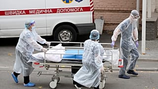 Medical staff members push a cart out of the COVID-19 infection department in a city clinic in Kyiv, Ukraine, Thursday, Oct. 21, 2021.