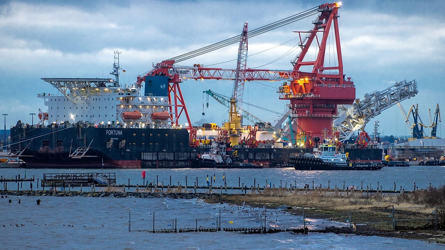 Remolcadores se ponen en posición en el buque ruso de colocación de tuberías "Fortuna" en el puerto de Wismar, Alemania, enero de 2021. 