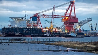 Remolcadores se ponen en posición en el buque ruso de colocación de tuberías "Fortuna" en el puerto de Wismar, Alemania, enero de 2021.