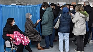 People wait for their turn at a vaccination center in Kramatorsk, Ukraine, Friday, Oct. 22, 2021.