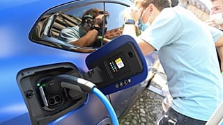 Visitors take a look at an electric car at the stand of German car maker BMW at the Max-Joseph-Platz square in Munich, southern Germany,