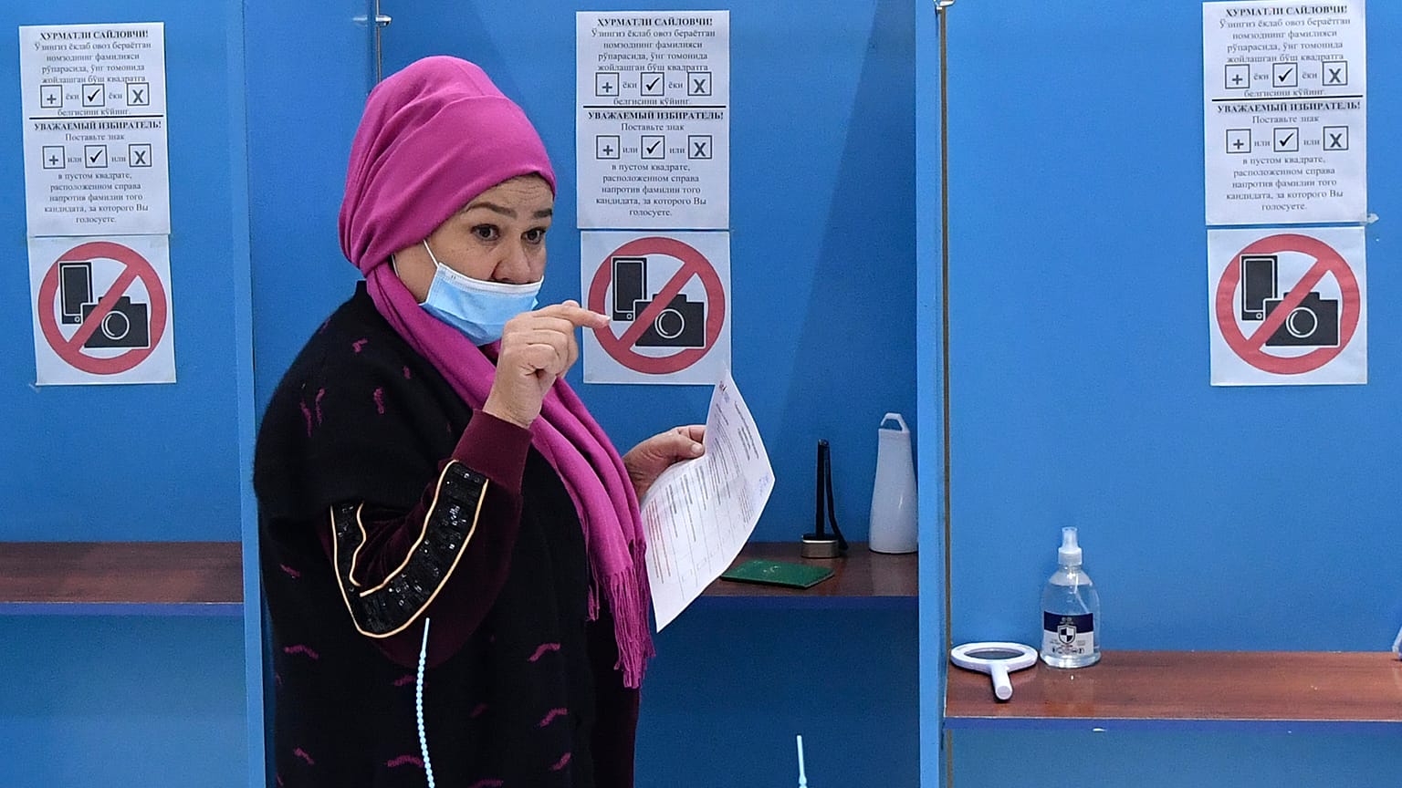 A woman walks to cast her ballot at a polling station during the presidential election in Tashkent, Uzbekistan, Sunday, Oct. 24, 2021. 