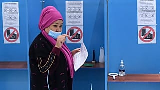 A woman walks to cast her ballot at a polling station during the presidential election in Tashkent, Uzbekistan, Sunday, Oct. 24, 2021. 