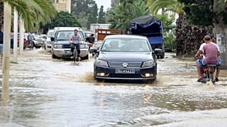 سيارة تسير على طريق غمرته المياه بعد هطول أمطار غزيرة في ولاية نابل التونسية.