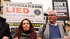 Julian Assange's partner Stella Morris, left, and Wikileaks editor-in-chief Kristin Hrafnsson hold placards and take part in a march in London, Saturday, Oct. 23, 2021